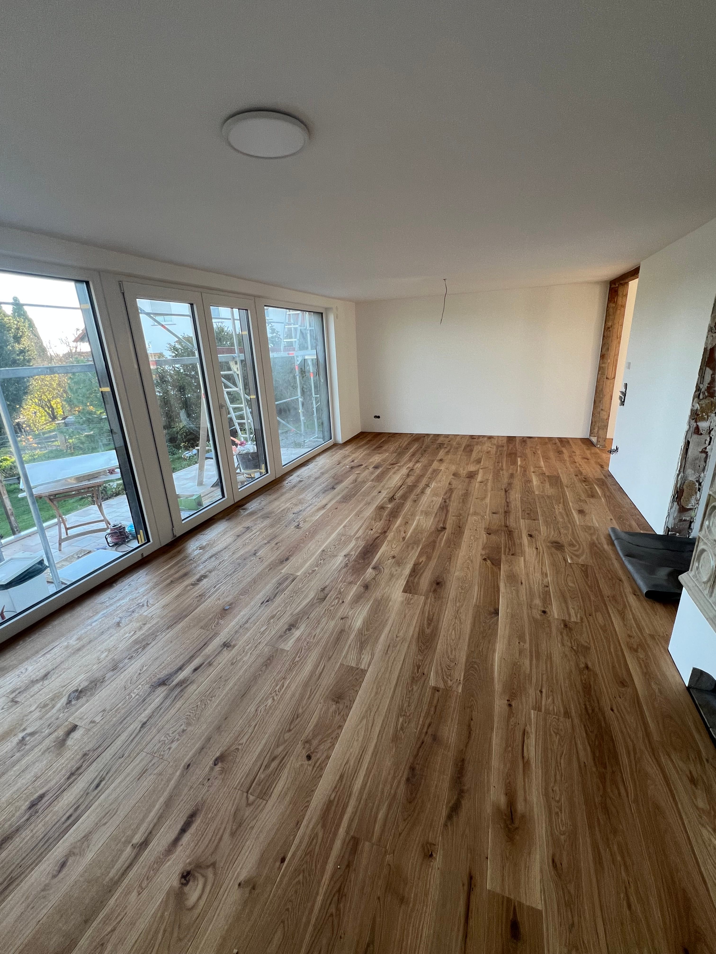 Heller Raum mit fertig verlegtem Holzboden