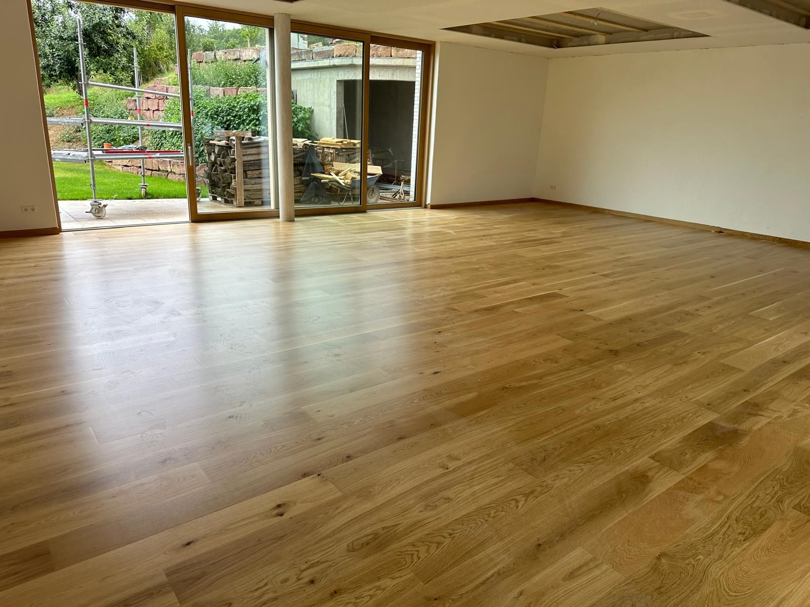 Heller Wohnbereich mit neu verlegtem Holzboden und Terrassentüren